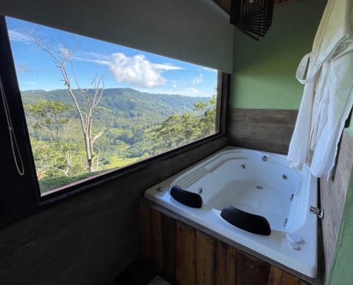 Banheira de hidromassagem luxuosa com vista para o vale das montanhas na villa Paraíso nas Montanhas em Campos do Jordão