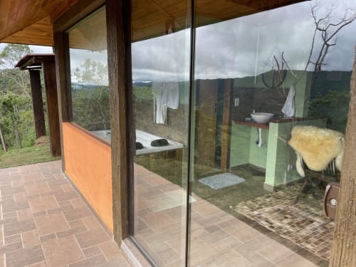 Banheiro da villa de montanha no Paraíso nas Montanhas com banheira, vista panorâmica de Campos do Jordão e paisagem de floresta