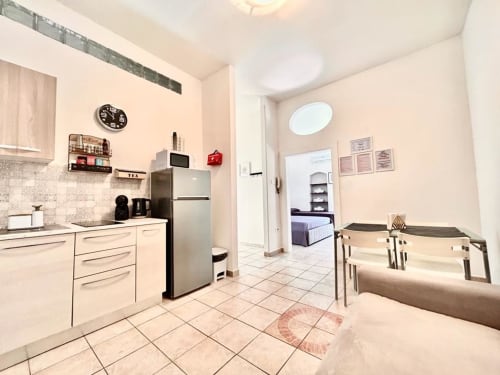 Cucina e zona pranzo moderna nell'appartamento Newhouse di Bari con elettrodomestici in acciaio inox e posti a sedere