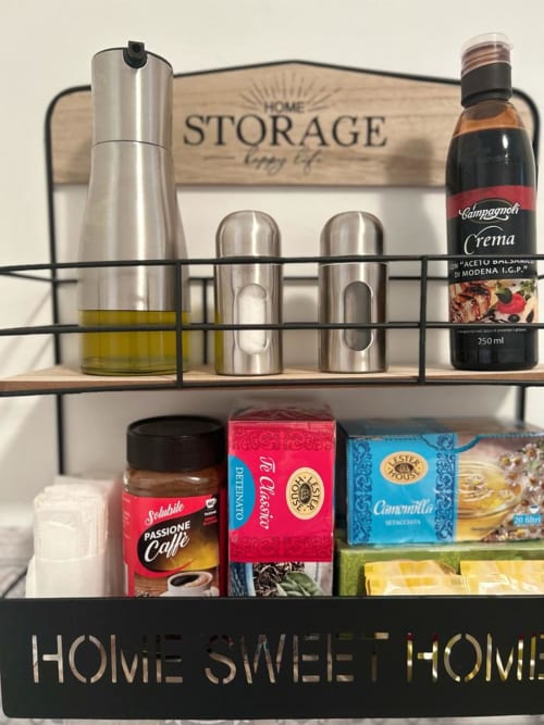 Scaffale per la dispensa di casa con prodotti tipici italiani, olio d'oliva, aceto balsamico e caffè in un appartamento a Bari