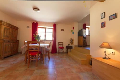 Salle à manger spacieuse aux meubles en bois et accents rouges au Gîte La Grange à Neuf-Brisach