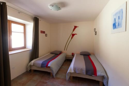 Chambre twin du Gîte La Grange, Neuf-Brisach avec deux lits simples et décoration murale aux fleurs rouges