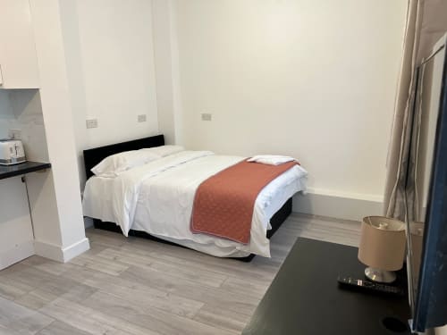 Modern hotel bedroom at Starlet Property London with bed, white linens, and contemporary furnishings