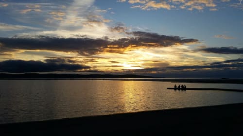 Sunset over the Dee estuary at West Kirby with silhouetted rowers on calm water