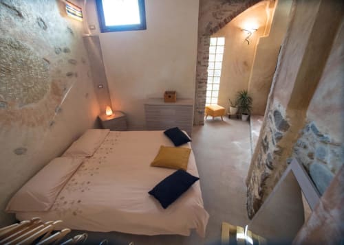 Camera rustica a CasaRosada B&B a Vidracco con muri in pietra, biancheria bianca e illuminazione calda