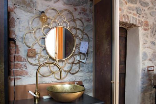 Specchio in ottone ornato sopra lavabo dorato con rubinetto in ottone al B&B Casa Rosada a Vidracco, Italia