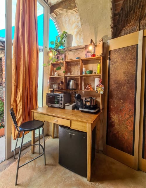 Accogliente angolo cottura a CasaRosada B&B a Vidracco con scrivania in legno, scaffali, frigorifero portatile e finestra con vista sulla terrazza.