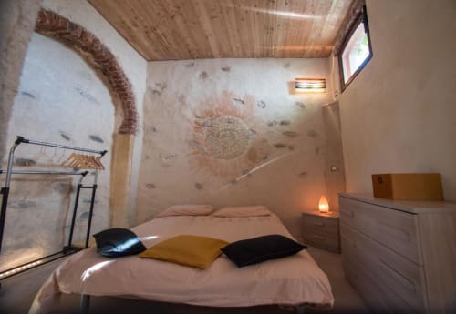 Camera accogliente di CasaRosada B&B a Vidracco con letto, soffitto in legno e muri in mattoni rustici