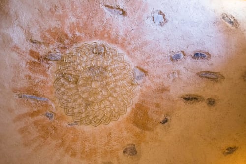 Rustic terracotta floor detail at CasaRosada B&B in Vidracco with mandala pattern and organic marks