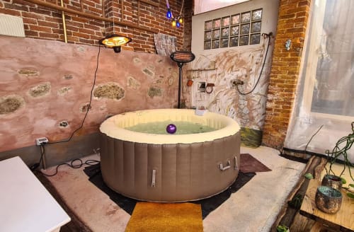 Inflatable hot tub in brick-walled spa room at CasaRosada B&B in Vidracco, Italy