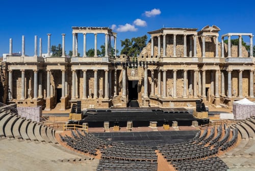 Ruinas del teatro romano de Mérida con columnas, arquitectura de piedra y asientos de anfiteatro bajo cielo azul