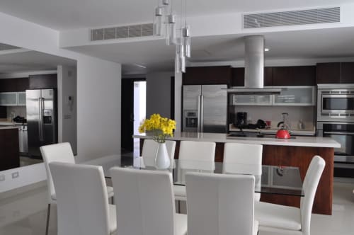 Cocina abierta y comedor moderno en el Resort Beachfront Mareazul de Playa del Carmen con electrodomésticos de acero inoxidable