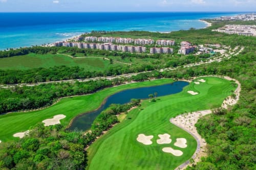 Campo de golf de Mareazul Resort frente al mar con vistas aéreas del turqueso Mar Caribe y búnkers de arena en Playa del Carmen, México