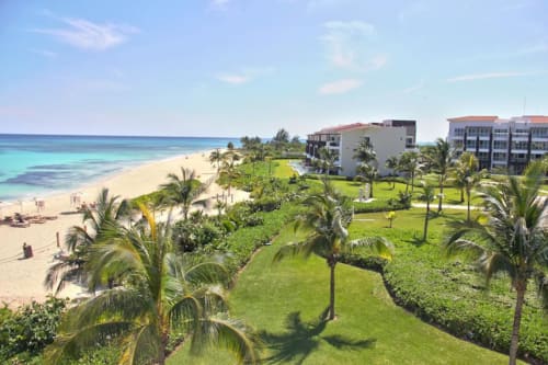 Resort Mareazul en Playa del Carmen con edificios frente al mar, jardines tropicales, palmeras y playas pristinas