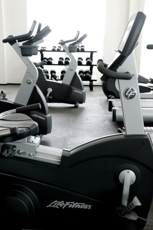 Equipamiento moderno de gimnasia en el Resort Frente al Mar Mareazul en Playa del Carmen con bicicletas estacionarias y pesas