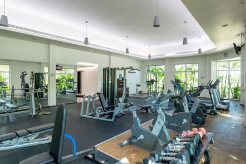 Centro de fitness moderno en Mareazul Beachfront Resort de Playa del Carmen con bicicletas estáticas, mancuernas y equipos de gimnasio