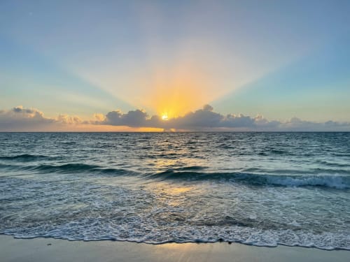 Amanecer sobre el Mar Caribe en Mareazul Beachfront Resort en Playa del Carmen con olas y playa de arena
