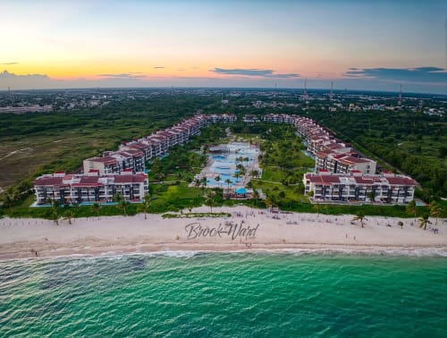 Mareazul Resort frente al mar, vista aérea con edificios rosa, piscinas, playa y aguas turquesas en Playa del Carmen