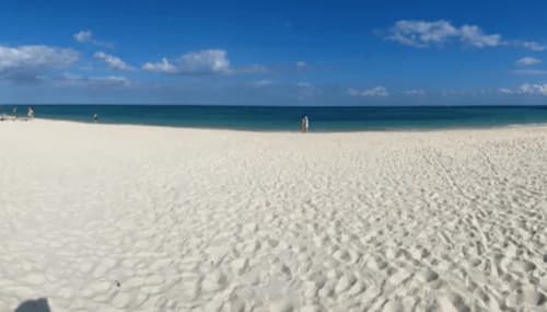 Playa de arena blanca inmaculada en Mareazul Beachfront Resort, Playa del Carmen, con aguas turquesas y cielo azul