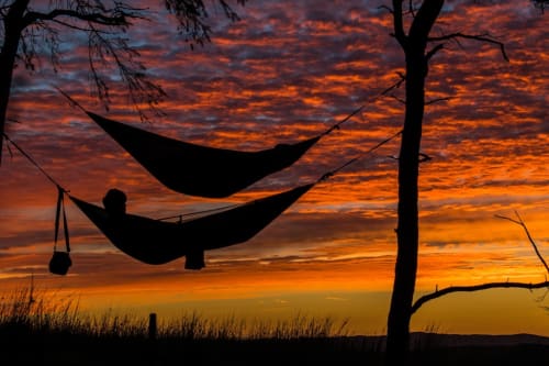 Silhouette of person relaxing in hammock at sunset, CasaRosada B&B in Vidracco, Italy