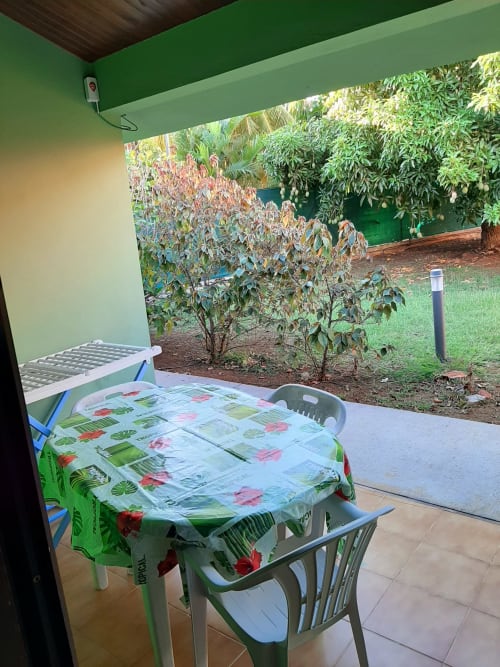 Garden-view balcony with table and chairs at Residence de Vacances Mon Refuge in Martinique, overlooking tropical plants and
