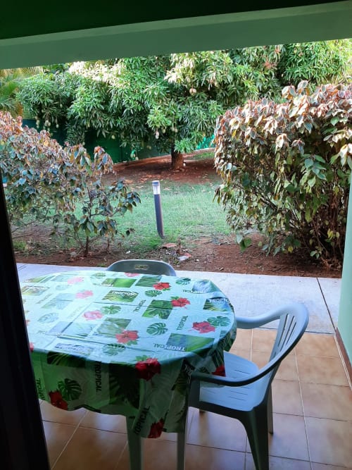Garden view from Serenity apartment balcony at Mon Refuge hotel with dining table and tropical vegetation in Les Anses