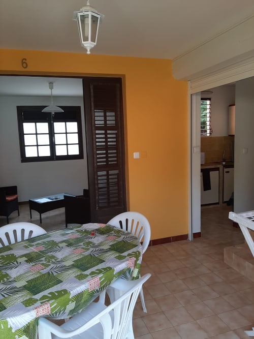 Salle à manger avec nappe à motifs et chaises blanches à Mon Refuge, Les Anses d'Arlet, Martinique