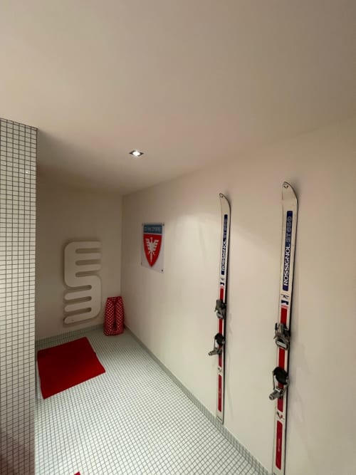 Rangement à skis du Chalet Du Sarrasin à Tignes avec skis Rossignol muraux et sèche-serviettes chauffant