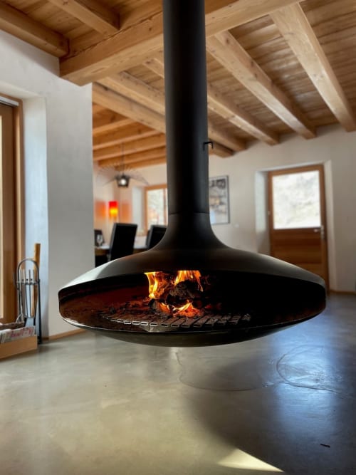 Foyer suspendu contemporain avec flammes actives à l'Appart Chalet Du Sarrasin, Tignes, poutres en bois apparentes et béton