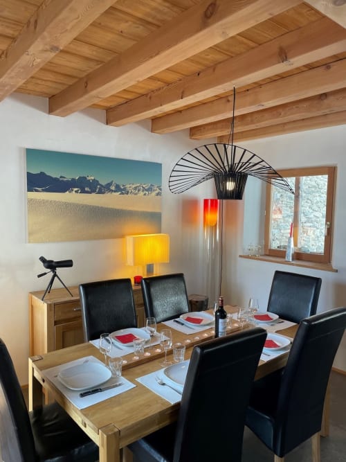 Salle à manger du Chalet Du Sarrasin à Tignes avec poutres apparentes, table dressée et décoration montagne
