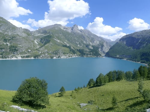 Lac alpin entouré de montagnes et de prairies verdoyantes près de Tignes, France