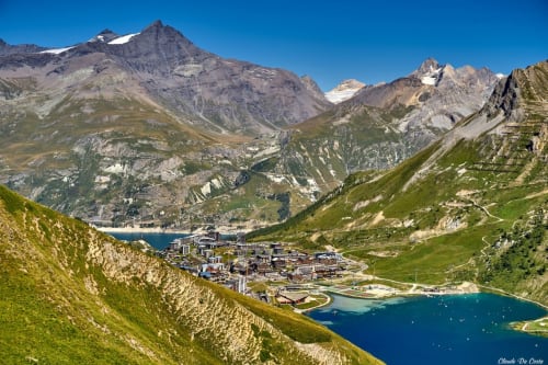 Station alpine de Tignes nichée dans les montagnes entre des lacs turquoise, entourée de pentes verdoyantes