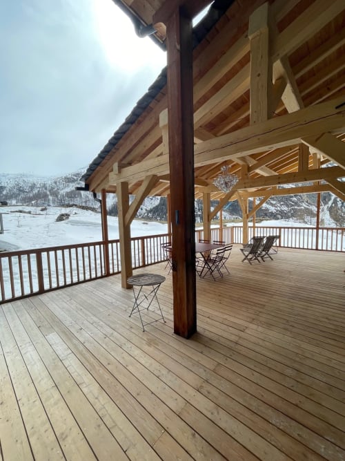 Terrasse couverte du Chalet Du Sarrasin avec vue sur le lac et les montagnes enneigées de Tignes