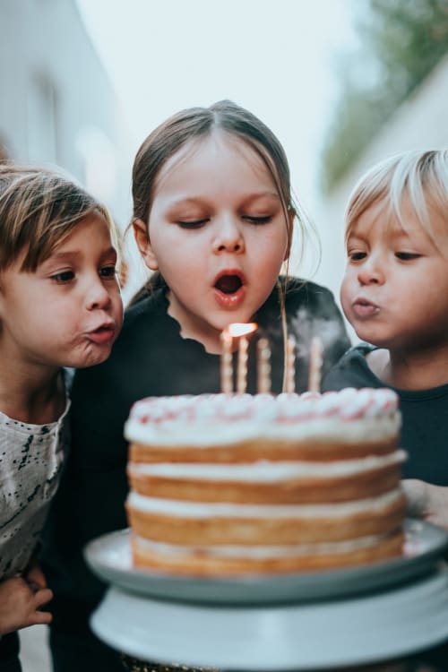 Three children blowing out candles on a birthday cake at Sliabh Beagh Hotel in Monaghan
