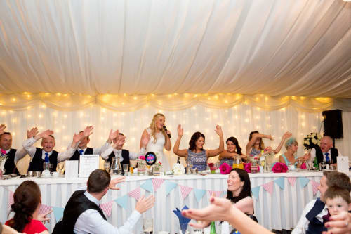 Wedding reception at Sliabh Beagh Hotel with guests celebrating at decorated tables under elegant white draping and string