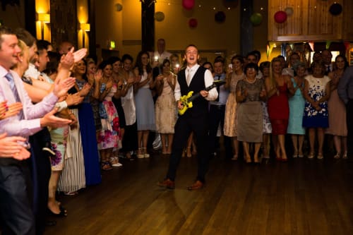 Man playing yellow guitar at Sliabh Beagh Hotel wedding reception with guests clapping in Monaghan
