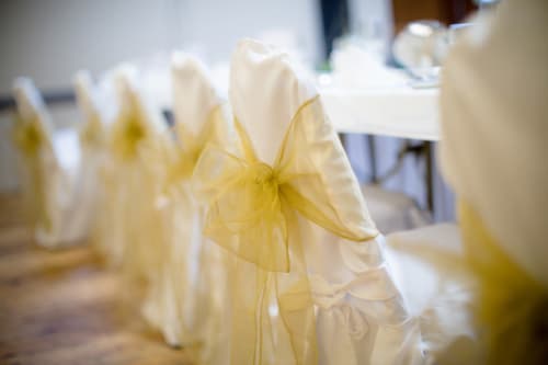 White chair covers with yellow organza bows at Sliabh Beagh Hotel event setup in Monaghan
