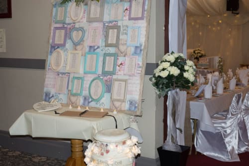 Wedding reception seating chart display at Sliabh Beagh Hotel with guest name cards and white floral centerpiece