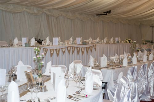 Elegant wedding reception at Sliabh Beagh Hotel with decorated tables, white linens, and 'Just Married' banner.