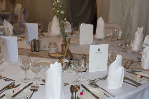 Elegant formal dining table setting at Sliabh Beagh Hotel with white napkins, place settings, and floral centerpiece