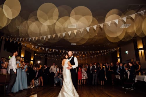 Bride and groom's first dance at Sliabh Beagh Hotel wedding reception with bunting and golden lights