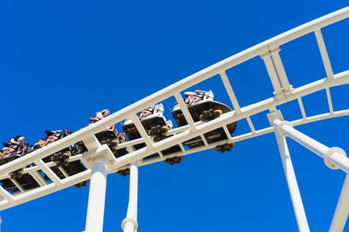 Montagnes russes sous un ciel bleu cristallin, attraction palpitante du parc d'attractions