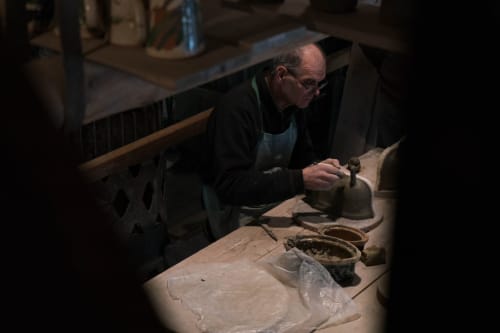 Artisan potier travaillant à sa table en bois à la Gîte La Grange, Neuf-Brisach