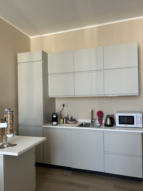 Cucina moderna della B&B Breccia nel Mare a Marina di Carrara con mobili bianchi e elettrodomestici in acciaio inox