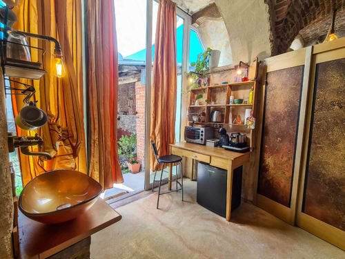 Sala benessere di CasaRosada B&B a Vidracco con lavabo in rame, scrivania in legno, scaffali, accesso alla terrazza e vista sul giardino