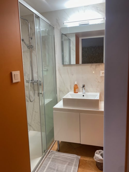 Salle de bains moderne avec douche à l'italienne, vasque et accents en marbre au Château Haut Clarise, Belvès-de-Castillon