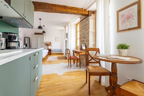 La Maison George apartment with green kitchen, wooden beams, dining area and rustic stone fireplace in Flavigny sur Ozerain