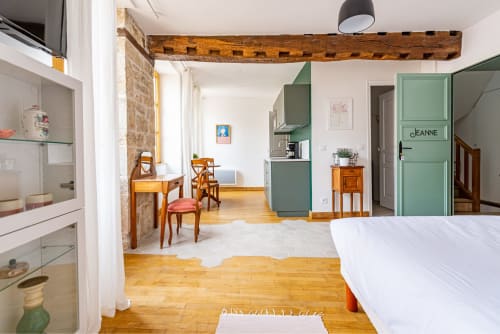 Logis Jeanne apartment at La Maison George, Flavigny sur Ozerain, with bed, dining area, green door, and wooden beams