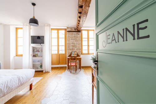 Logis Jeanne apartment at La Maison George in Flavigny sur Ozerain, France, featuring wooden beams, green door, and bright