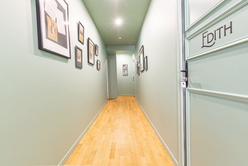 Entrée du couloir de l'appartement Logis Edith à La Maison George à Flavigny-sur-Ozerain, avec parquet et œuvres d'art encadrées